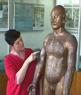 picture of Maria Mercati examining bronze statue of acupuncture points